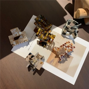 Close-up of acetic acid hair clips in leopard, checkerboard, and marble patterns