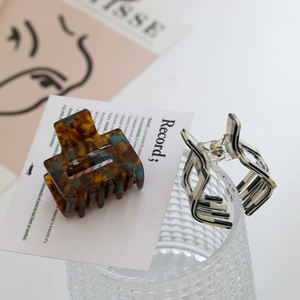 Close-up of square acetate hair claws with leopard and zebra patterns on aesthetic props