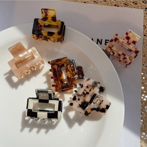 Macro detail of six acetate square hair clips in checkerboard and leopard prints