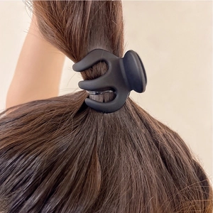 Matte black claw clip for high ponytail styling on brunette hair with secure grip design
