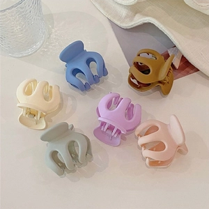 Close-up of small octopus-shaped hair claws in six matte macaron colors for women
