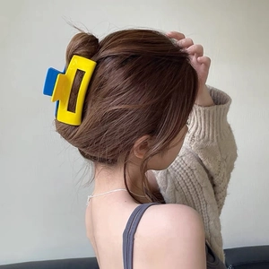 Detail shot of yellow and blue contrast geometric hair claw clip on model hair back