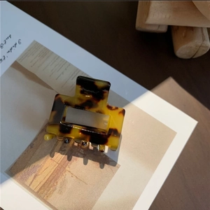 Detailed macro view of the tortoiseshell square hair claw clip on white card background