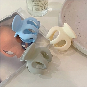 Three matte hair claw clips in pastel blue, cream, and sage green for high ponytail styling