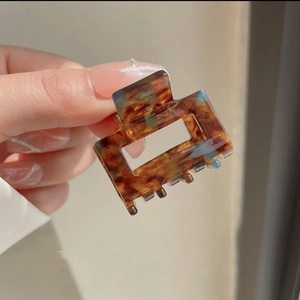 Close-up of square leopard checkered acetate hair claw with glossy tortoiseshell finish