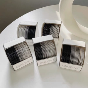 Detailed set of thick elastic hair ties in neutral tones on a minimalist white display
