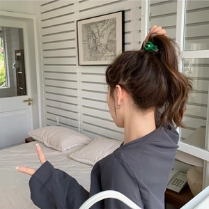 Mini green hair claw clip for high ponytail styling on woman with minimalist look