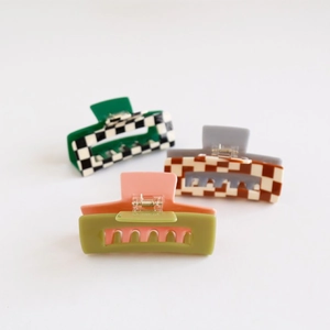 Detailed view of three checkered and color-blocked acetate hair claw clips set