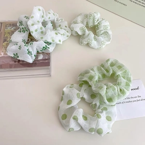 Dettaglio di quattro elastici in organza verde con motivi floreali, a pois e a scacchi