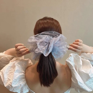Détail d'un chouchou en dentelle bleu clair à pois blancs pour coiffure élégante
