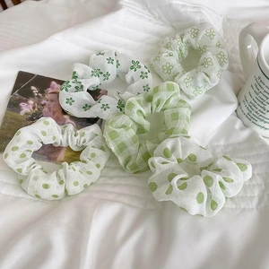 Dettaglio di set 5 elastici in organza verde con motivi floreali, pois e quadri