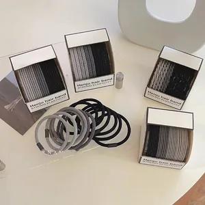 Detailed view of elastic woven hair ties in neutral tones on a clean minimalist surface