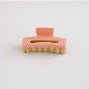 Detail view of pink and avocado green checkered acetate hair claw clip for elegant styling