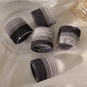 Close-up of high elasticity hair ties set in gradient grey tones on a glass tray