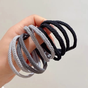Close-up of durable elastic hair ties with fishbone texture in neutral black and grey tones