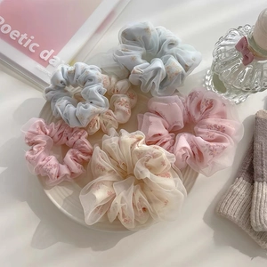 Gros plan de 6 chouchous en maille florale surdimensionnés aux couleurs pastel