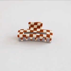Detailed close-up of brown checkerboard acetate hair claw clip with glossy finish