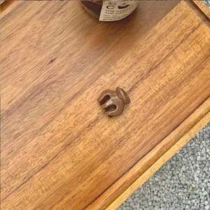 Detailed close-up of a mini brown resin hair claw clip on a warm wooden tray