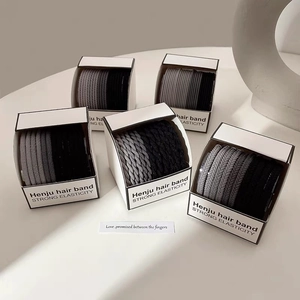 Detailed view of high-elasticity hair ties set in minimalist monochrome grey packaging