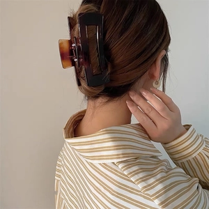 Side view of a large 12.5cm tortoiseshell hair claw clip securing a French bun hairstyle