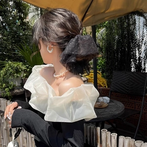 Élastique à cheveux élégant en dentelle noire à pois porté par un mannequin en extérieur