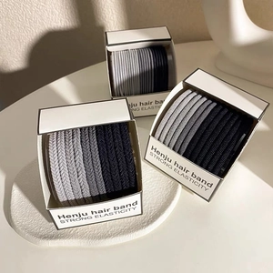 Detailed view of elastic hair bands in three colors inside a minimalist storage box