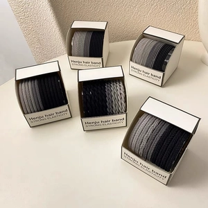 Detailed view of high elasticity hair bands in neutral tones with textured weave design