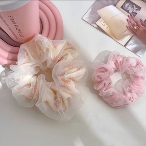 Gros plan détaillé de grands chouchous floraux en maille de tissu organza semi-transparent