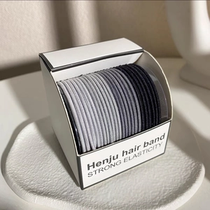 Detail of high elasticity hair bands in gray tones within minimalist Henju packaging box
