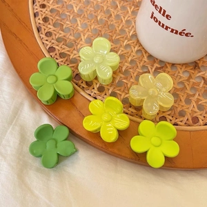 Vue détaillée de six pinces à cheveux en forme de fleur aux tons vert melon et jaune