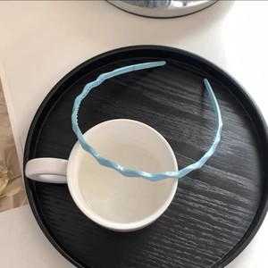Detail of light blue wave headband with non-slip teeth texture on white ceramic cup
