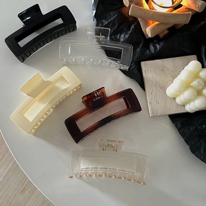 Top view of five colorful oversized square hair claws in minimalist plastic and metal