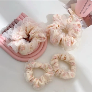 Vue détaillée des chouchous en tulle à fleurs avec couches d'organza et motifs roses