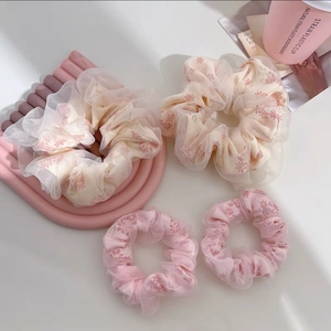 Détail de quatre chouchous en tulle surdimensionnés avec motifs floraux et volants doux