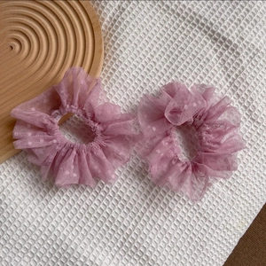 Vue détaillée des chouchous en dentelle lavande avec micro-pois sur tissu texturé