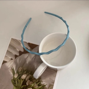 Detailed view of a light blue wavy headband with non-slip teeth for secure daily wear