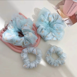 Gros plan sur chouchous en organza bleu clair avec fleurs de marguerites et maille