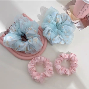 Détail des chouchous en tulle à fleurs bleu clair et rose avec design élégant double couche