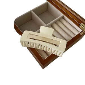Matte cream rectangle hair claw clip for thick hair displayed on a wooden jewelry box