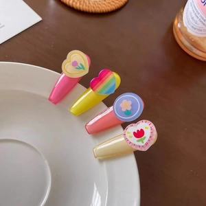 Close-up of colorful tulip and daisy hair clips set on a white ceramic plate