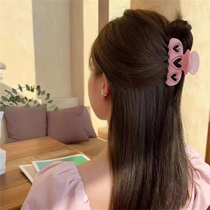 Pince à cheveux rose en forme de cœur avec découpe noire portée en chignon