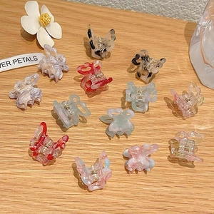 Macro shot of colorful gradient butterfly hair clips with elegant marble patterns