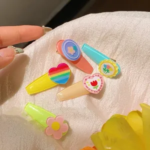 Set of 5 colorful resin hair clips with tulip and rainbow heart designs on white fabric