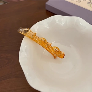 Gros plan sur la pince à cheveux ambre dégradé avec design d'anneaux évidés élégant