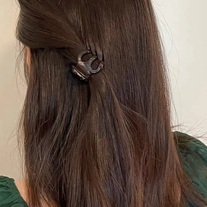 Close-up of small tortoiseshell hair claw clip securing a high ponytail on brown hair