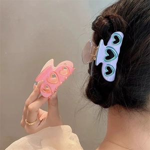 Détail des pinces à cheveux coeur évidé rose et violet avec finition en résine
