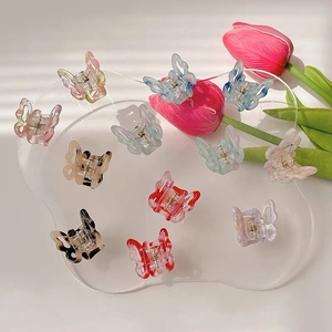 Detailed view of colorful gradient butterfly hair clips in various pastel resin finishes