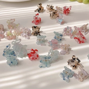 Detailed macro shot of mini butterfly hair clips with colorful marble and gradient patterns