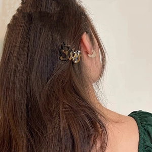 Detail view of a small tortoise shell hair claw clip holding hair in place securely