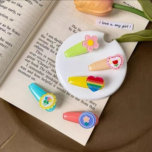 Detailed close-up of colorful acrylic tulip and heart hair clips on a white tray